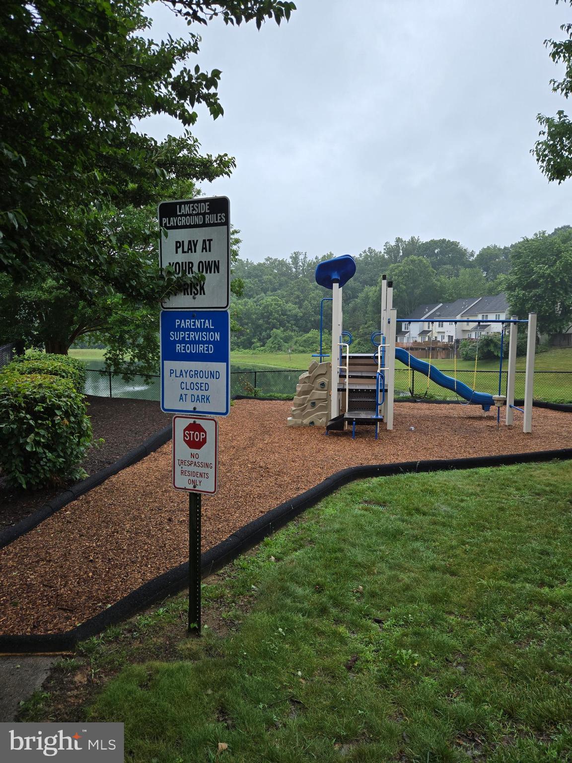 14151 Cuddy Loop, Unit 101 Woodbridge, VA 22193 - Photo 38 of 45 a sign board with a play ground in the back