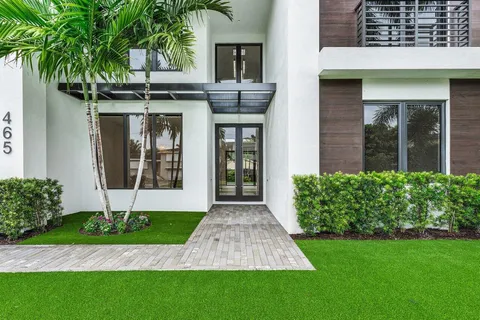 a front view of a house with a yard and potted plants