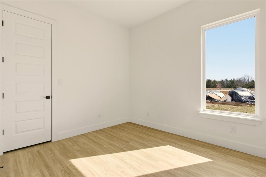 8902 Lowell Street Rowlett, TX 75089 - Photo 10 of 32 This room features light-colored flooring, white walls, and a white interior door with a black handle