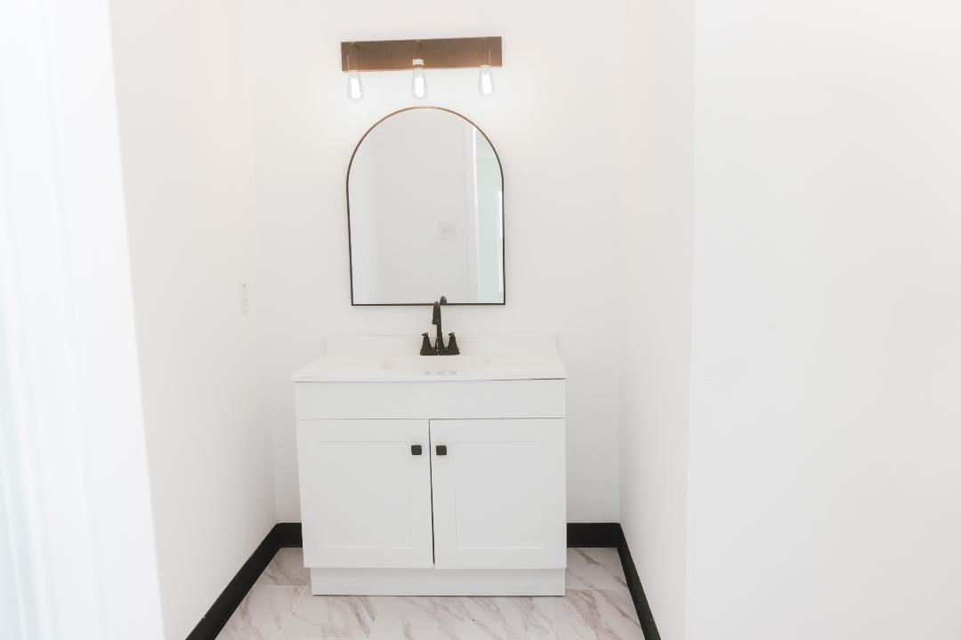 2513 Avenue H Rosenberg, TX 77471 - Photo 5 of 9 a bathroom with a sink and mirror