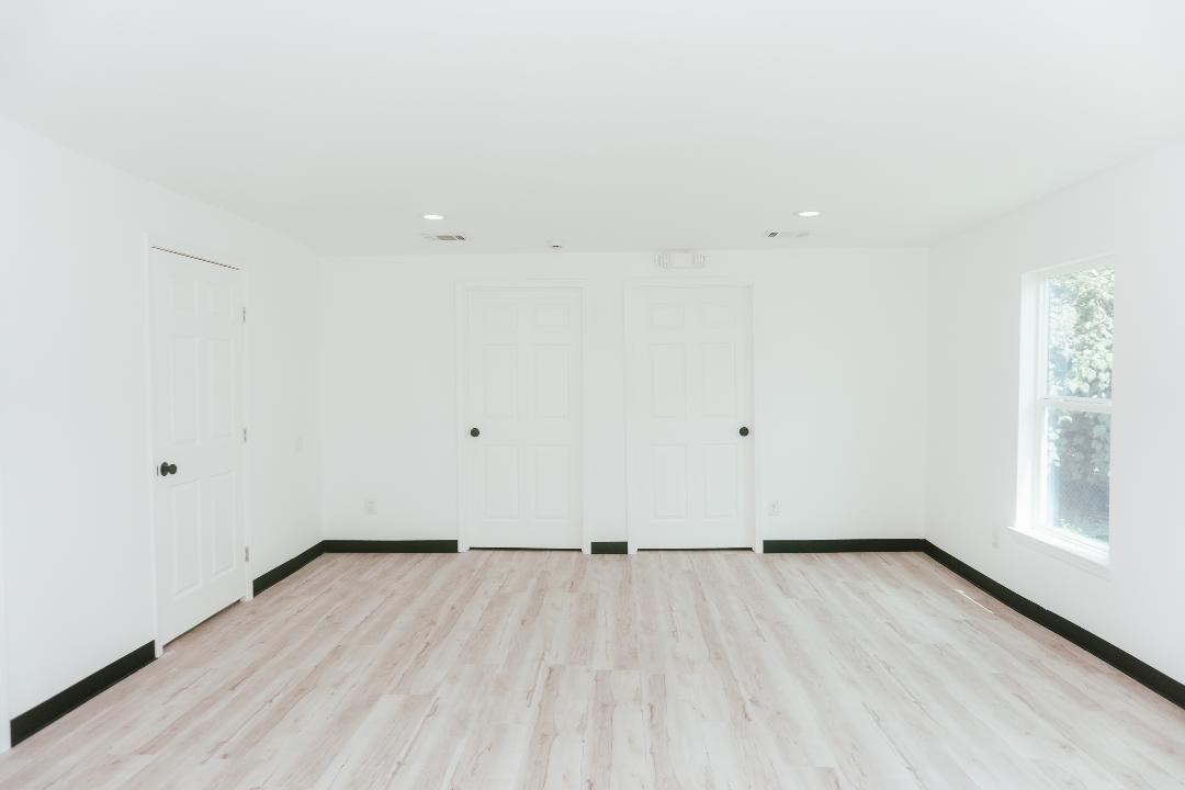 2513 Avenue H Rosenberg, TX 77471 - Photo 7 of 9 an empty room with wooden floor and windows