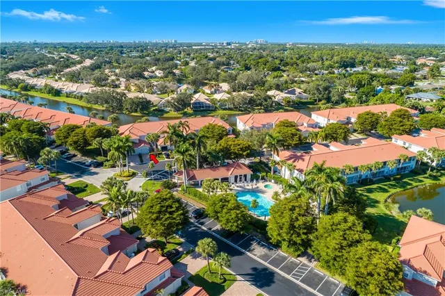 an aerial view of residential houses with outdoor space and trees