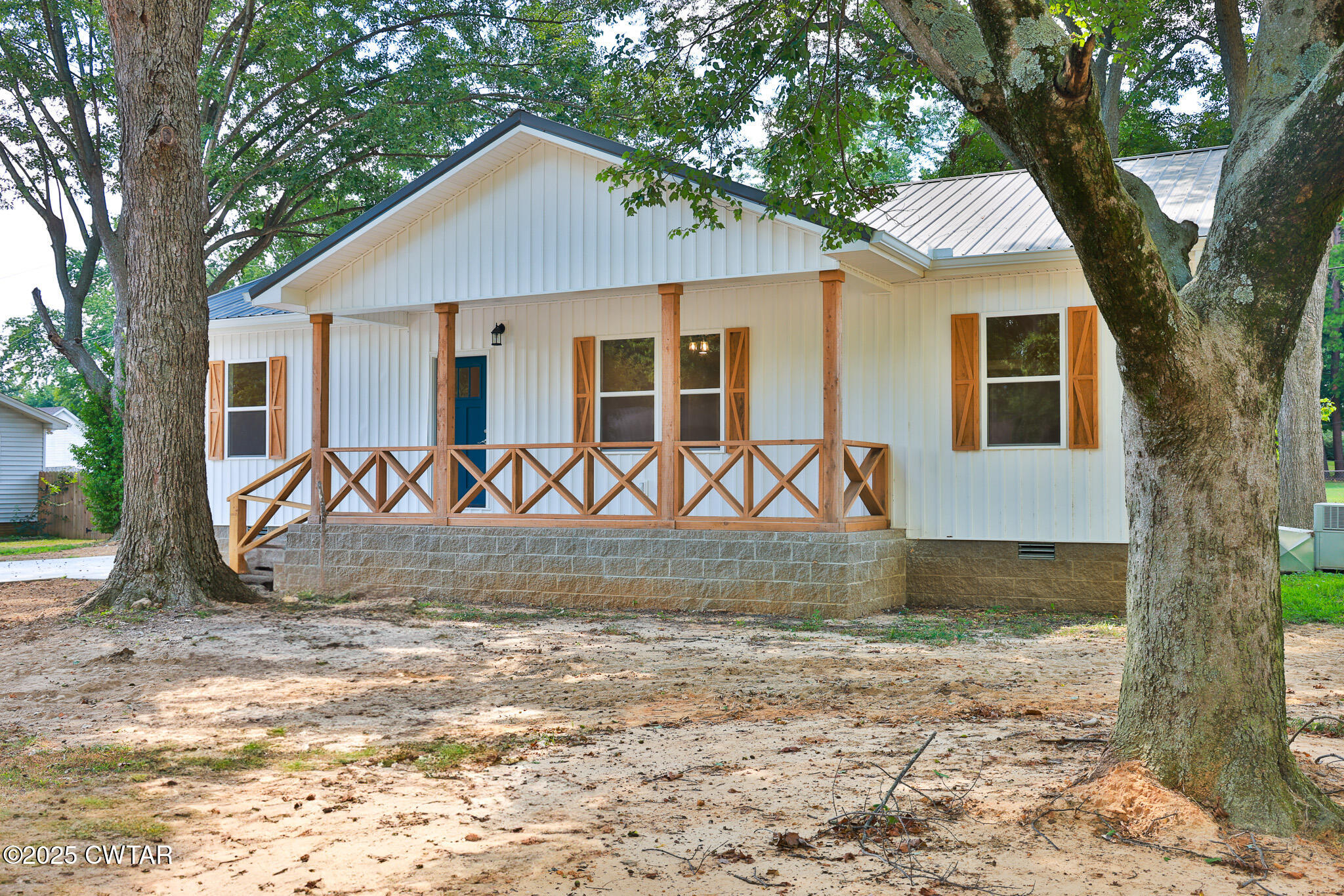 a view of a house with backyard and a tree