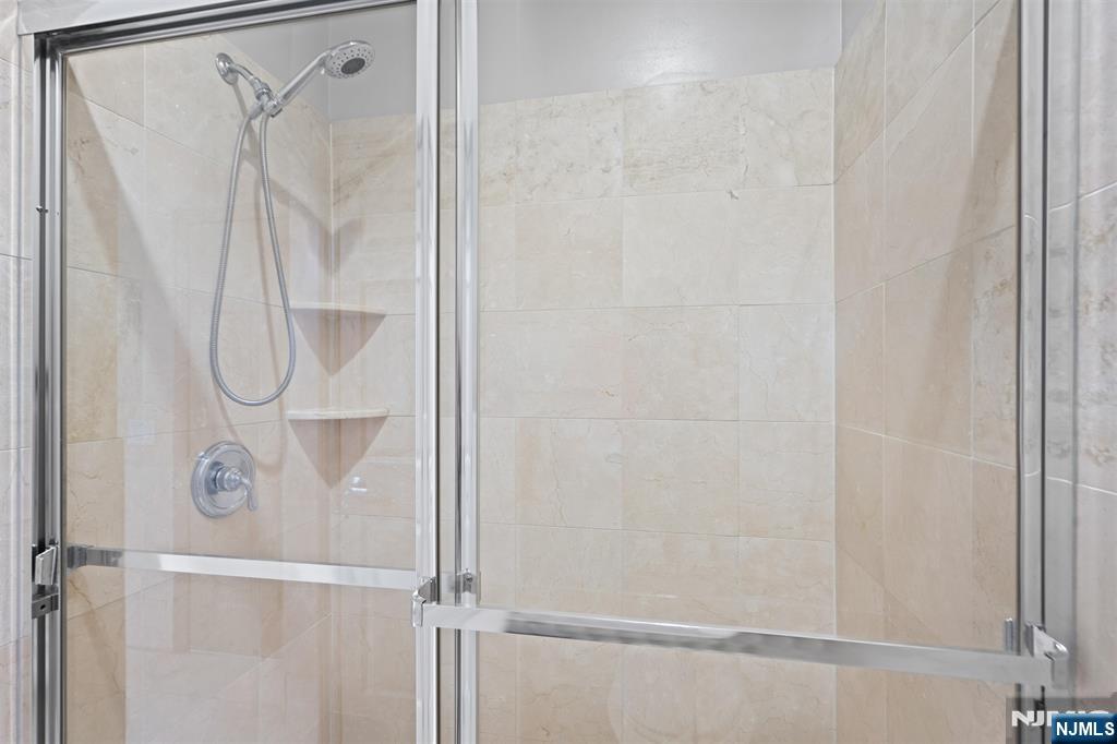 7400 River Road, Unit 116 North Bergen, NJ 07047 - Photo 11 of 32 a bathroom with a glass shower door