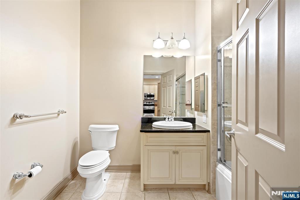 7400 River Road, Unit 116 North Bergen, NJ 07047 - Photo 14 of 32 a bathroom with a toilet a sink and a mirror