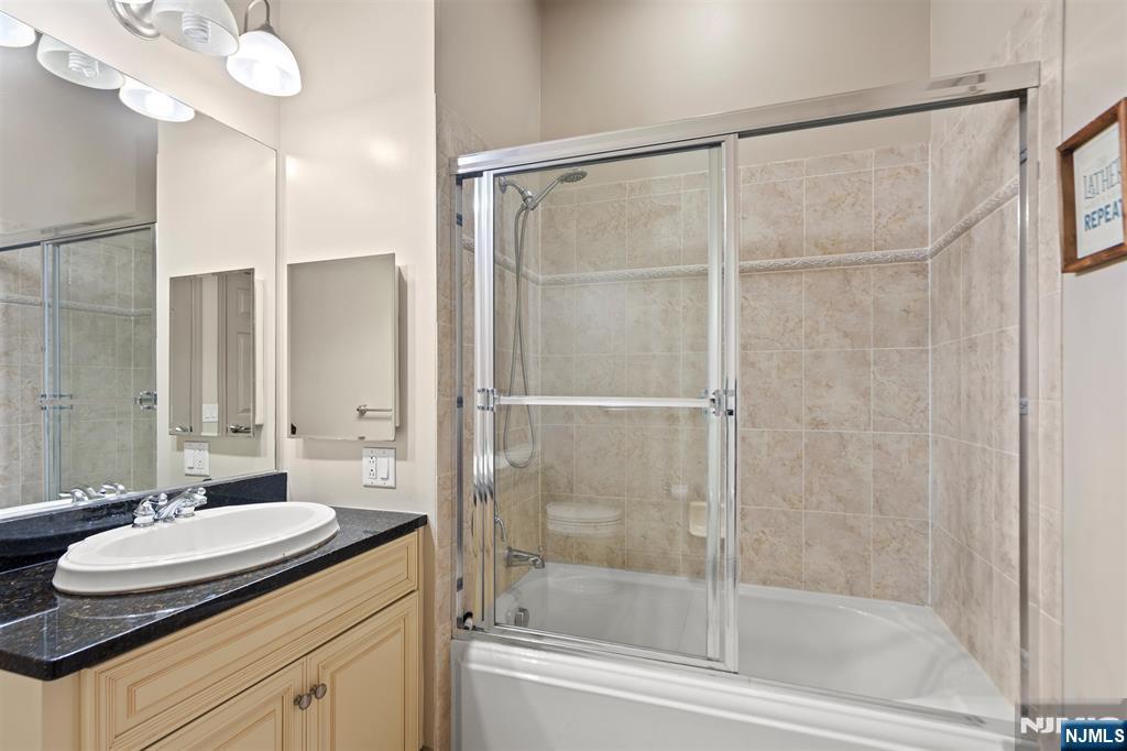 7400 River Road, Unit 116 North Bergen, NJ 07047 - Photo 15 of 32 a bathroom with a granite countertop sink mirror and a bathtub