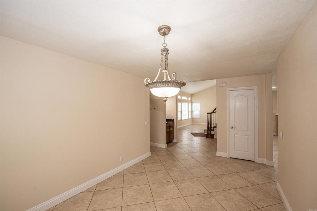 28679 Corte Capri Menifee, CA 92584 - Photo 19 of 66 a view of a hallway with wooden floor and a chandelier