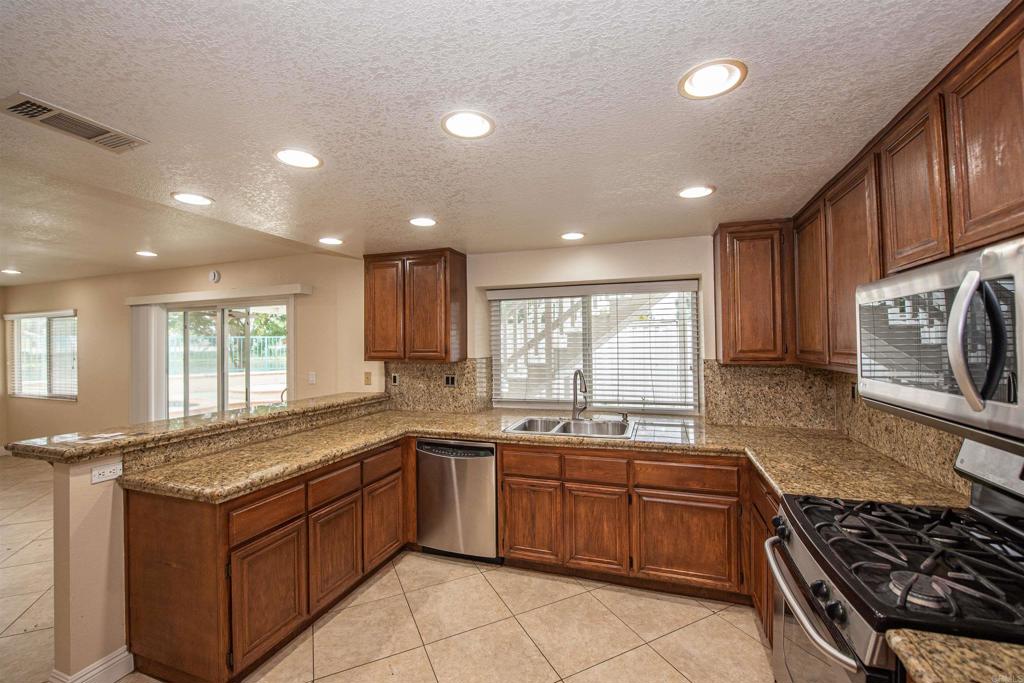 28679 Corte Capri Menifee, CA 92584 - Photo 21 of 66 a kitchen with a sink stove top oven and cabinets