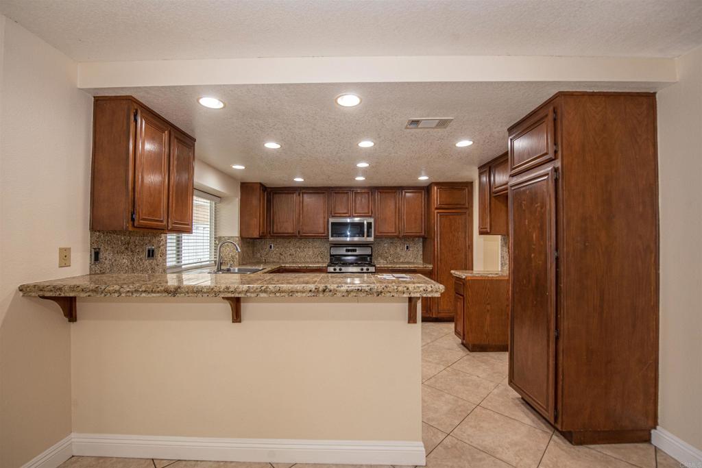 28679 Corte Capri Menifee, CA 92584 - Photo 31 of 66 a kitchen with stainless steel appliances granite countertop a sink a stove and a refrigerator