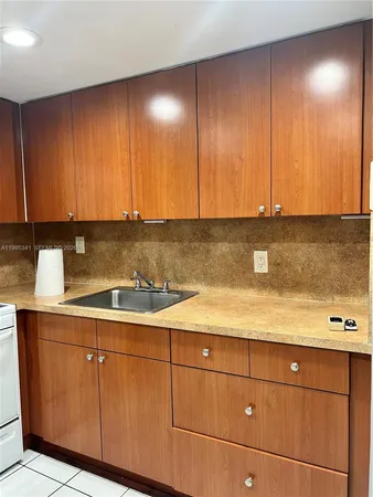 a kitchen with cabinets a sink and white cabinets