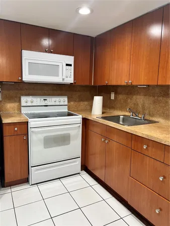 a kitchen with granite countertop cabinets and white appliances