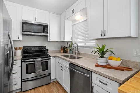 a kitchen with stainless steel appliances granite countertop a sink stove and microwave