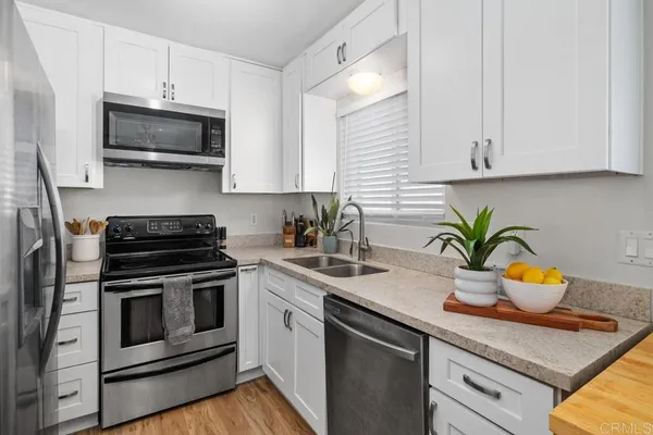 a kitchen with stainless steel appliances granite countertop a sink stove and microwave