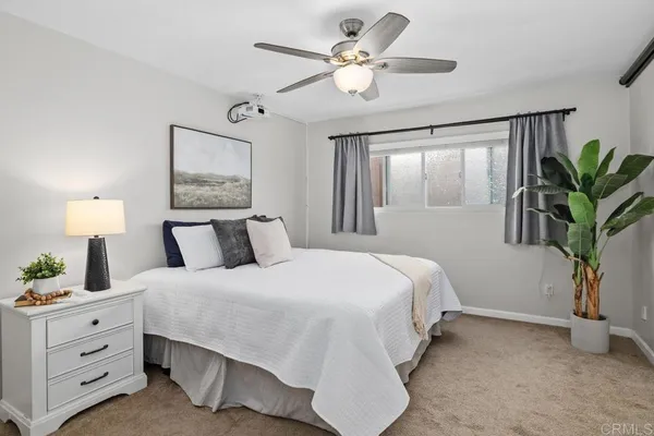 a bedroom with a large bed and a chandelier