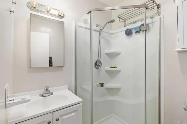 a bathroom with a sink shower and a mirror