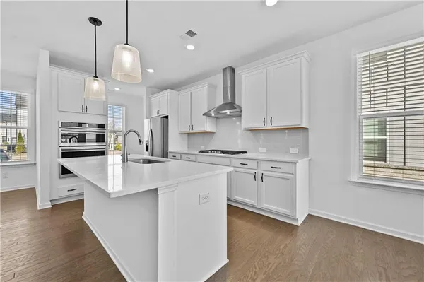 a kitchen with kitchen island granite countertop a sink a stove and a refrigerator