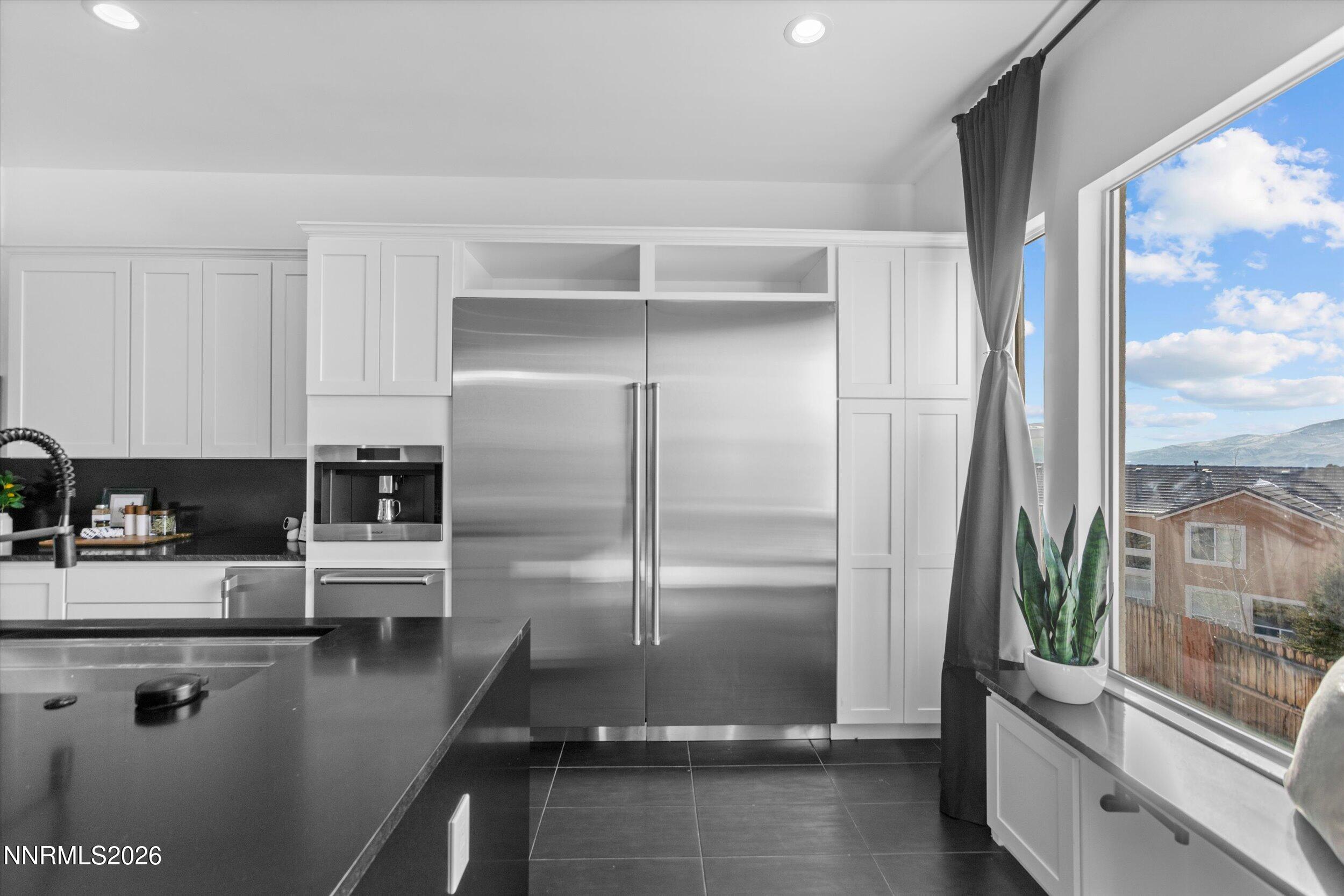 5850 Geode Court Reno, NV 89523 - Photo 12 of 88 a kitchen with kitchen island a counter top space a refrigerator and a view of living room