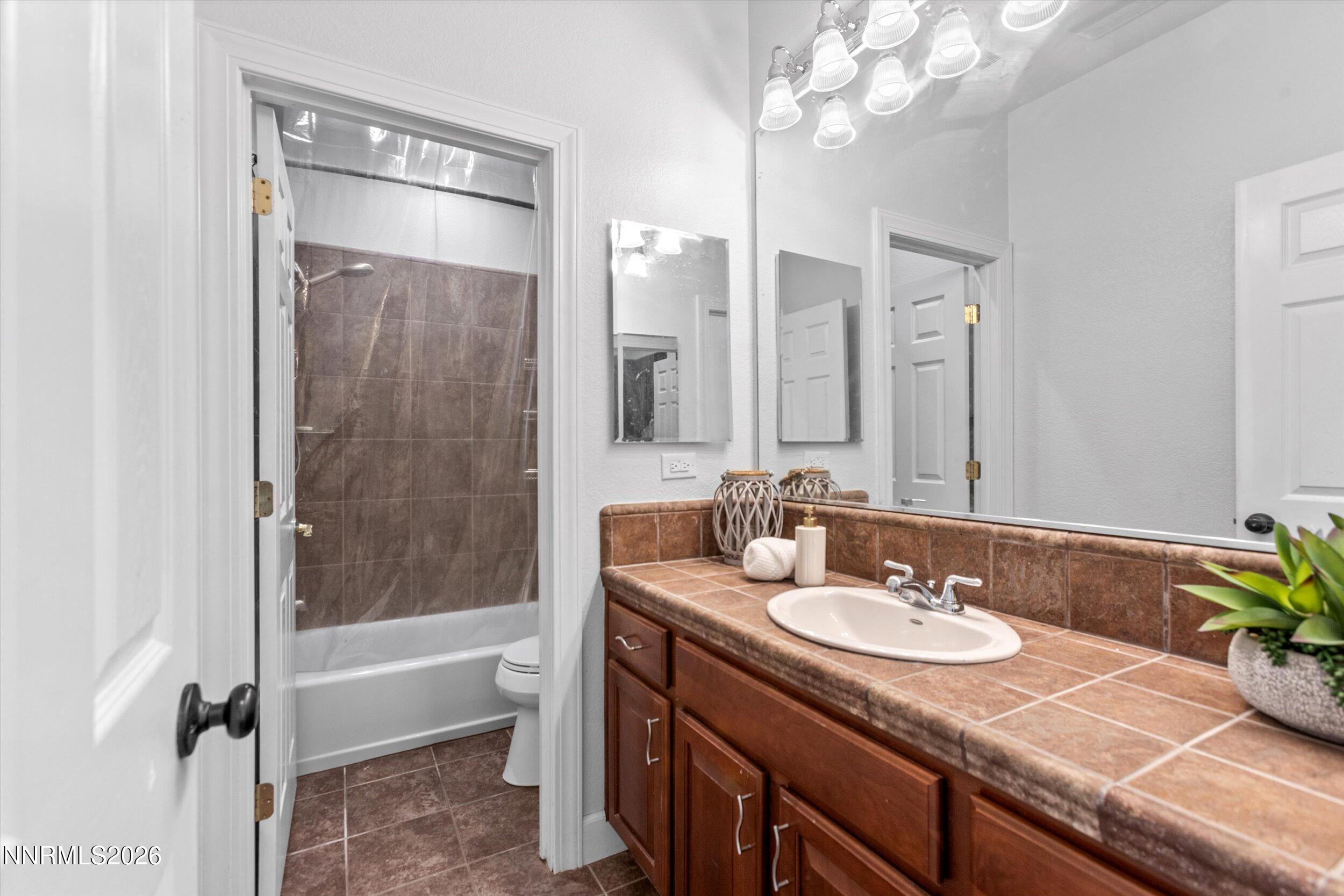 5850 Geode Court Reno, NV 89523 - Photo 55 of 88 a bathroom with a granite countertop sink a toilet and shower