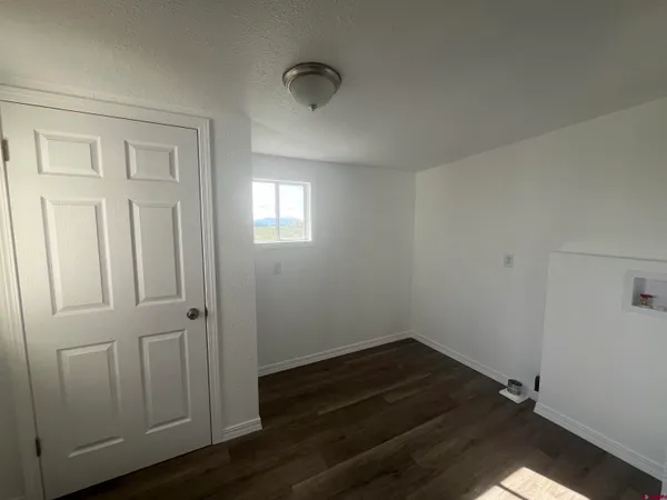 an empty room with wooden floor and closet