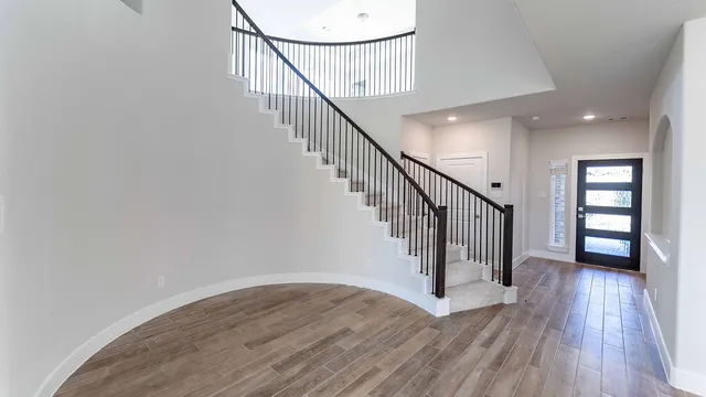 a view of staircase with wooden floor and white walls