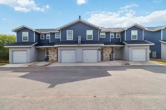 a front view of a house with a yard and parking
