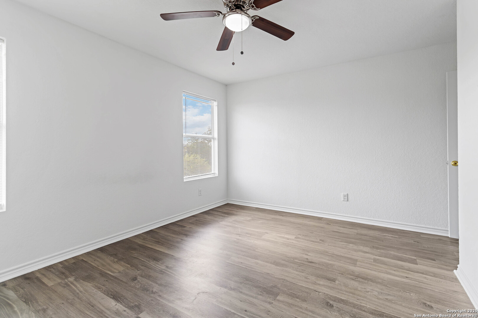 6942 Crestway Road San Antonio, TX 78239 - Photo 13 of 22 a view of an empty room with wooden floor and a window