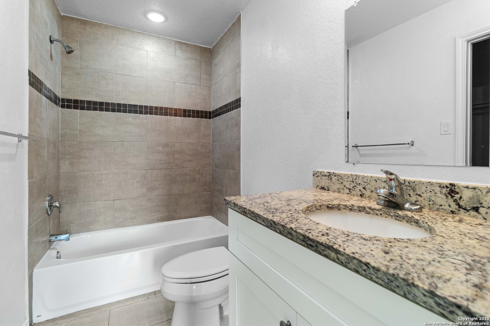 6942 Crestway Road San Antonio, TX 78239 - Photo 15 of 22 a bathroom with a granite countertop sink a toilet and shower