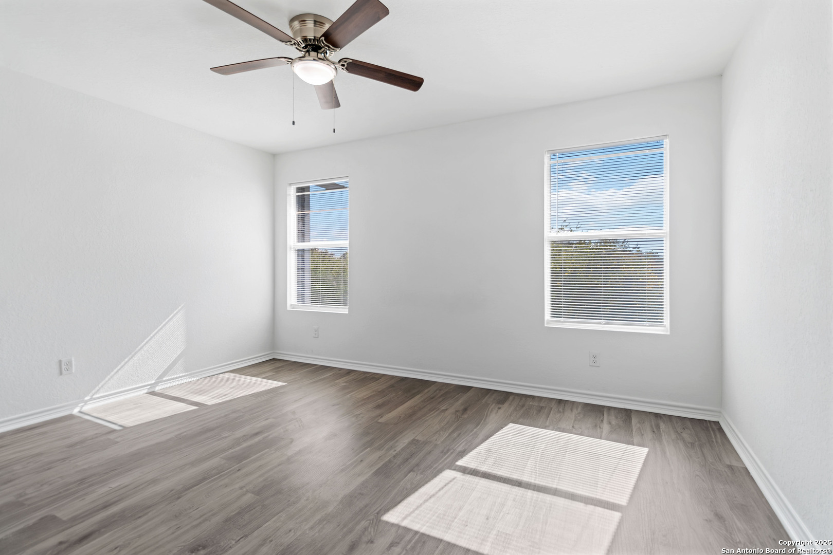 6942 Crestway Road San Antonio, TX 78239 - Photo 19 of 22 a view of an empty room with wooden floor and a window