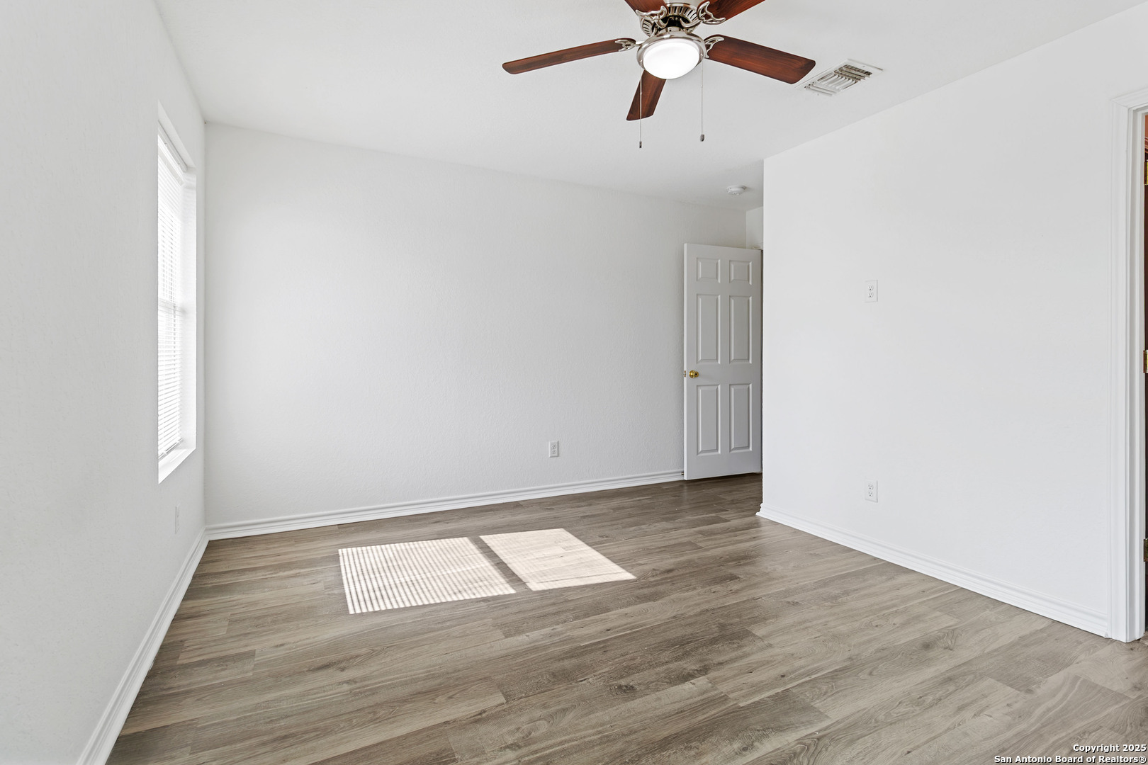 6942 Crestway Road San Antonio, TX 78239 - Photo 20 of 22 an empty room with wooden floor fan and windows