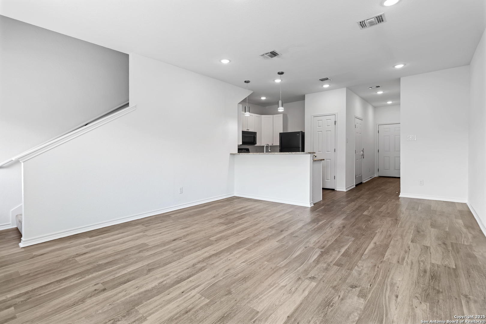 6942 Crestway Road San Antonio, TX 78239 - Photo 4 of 22 a view of a kitchen with wooden floor and a refrigerator