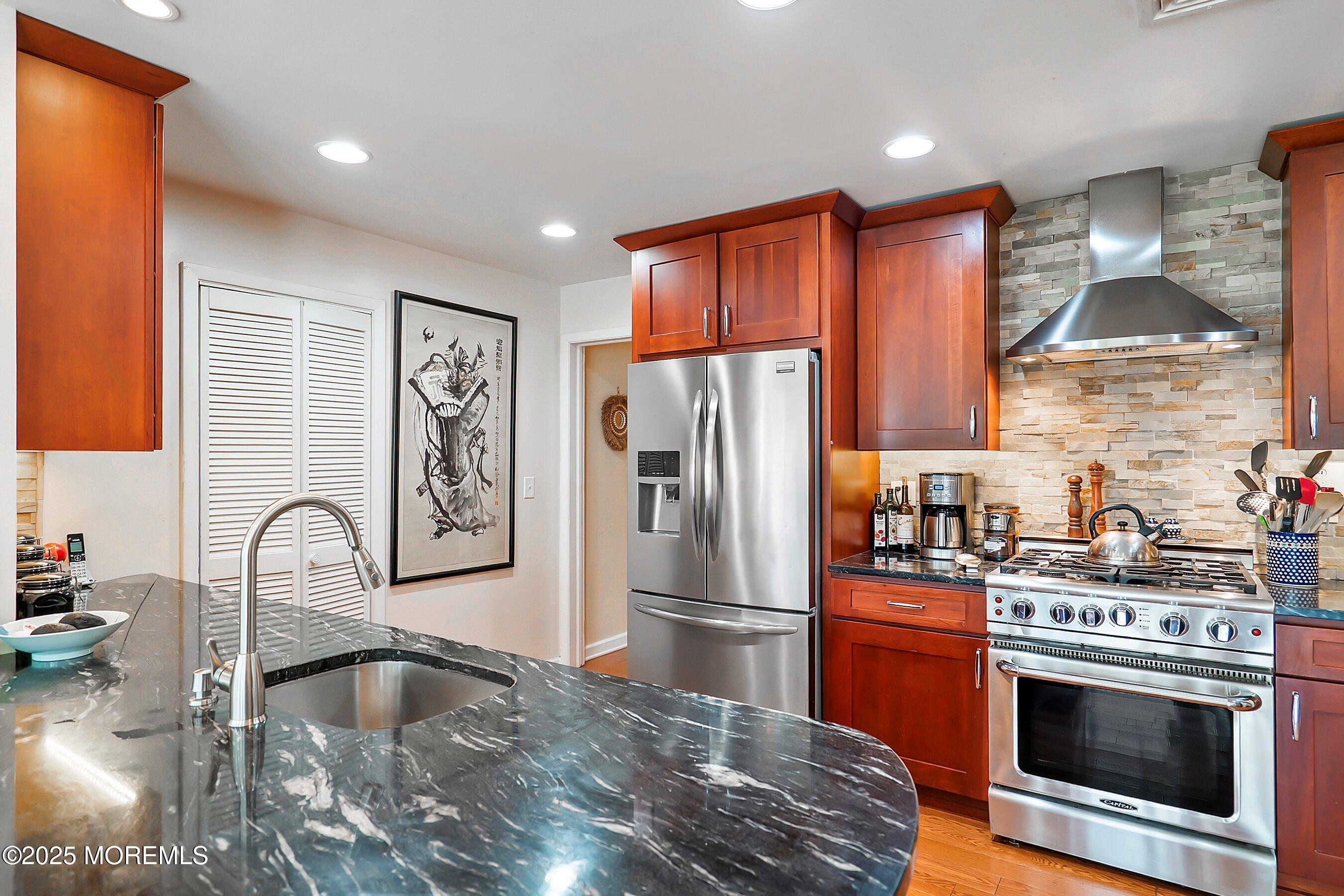 29 Holland Road Middletown, NJ 07748 - Photo 12 of 59 a kitchen with stainless steel appliances granite countertop a refrigerator a stove and a sink with wooden cabinets