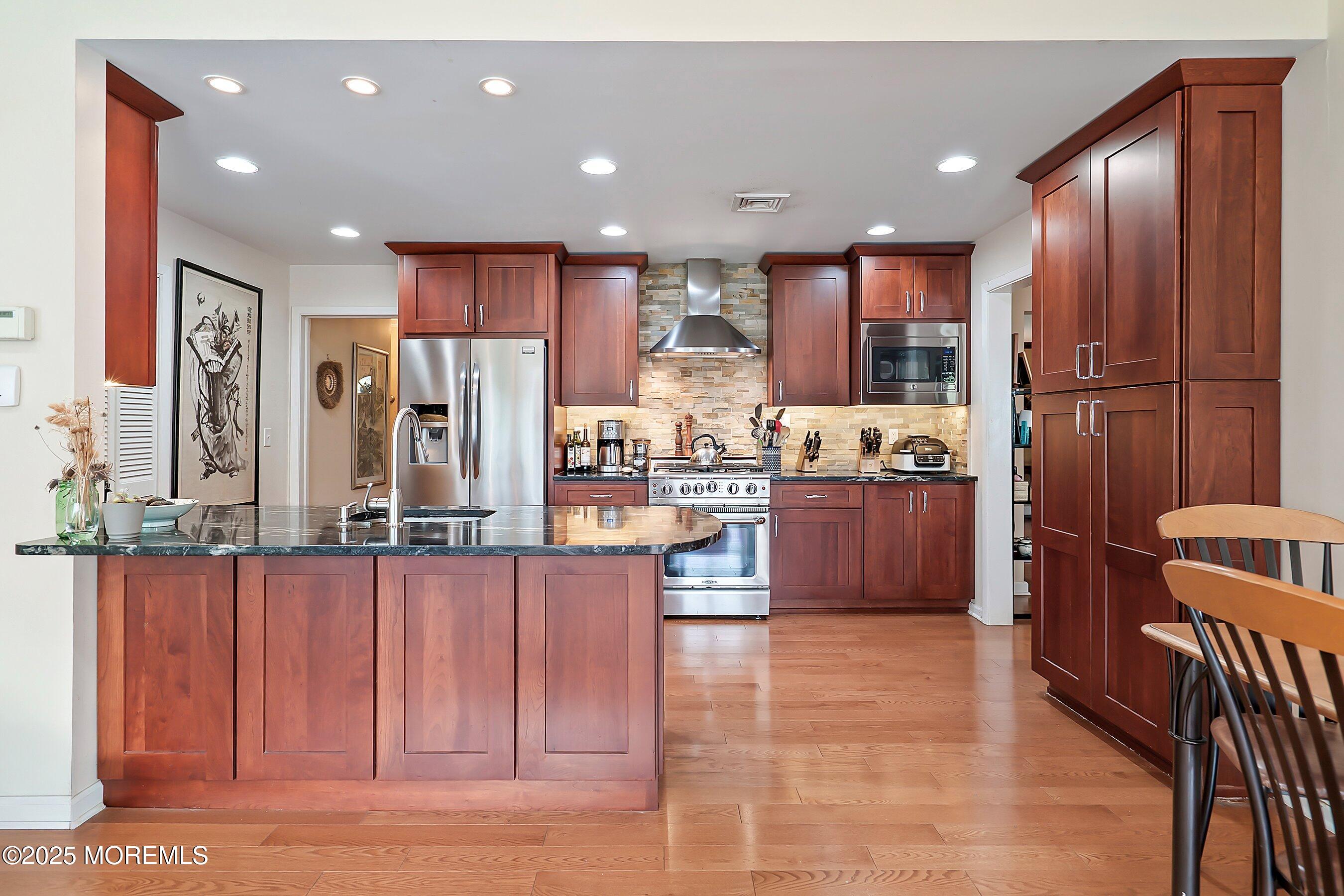 29 Holland Road Middletown, NJ 07748 - Photo 14 of 59 a large kitchen with stainless steel appliances kitchen island granite countertop a refrigerator and cabinets