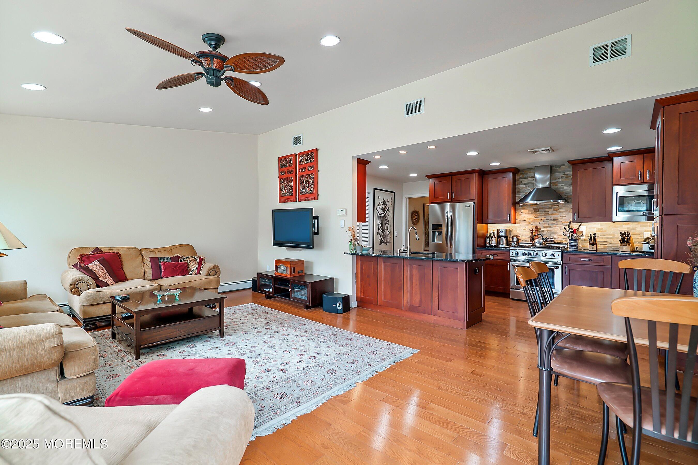 29 Holland Road Middletown, NJ 07748 - Photo 16 of 59 a living room filled with furniture and kitchen view