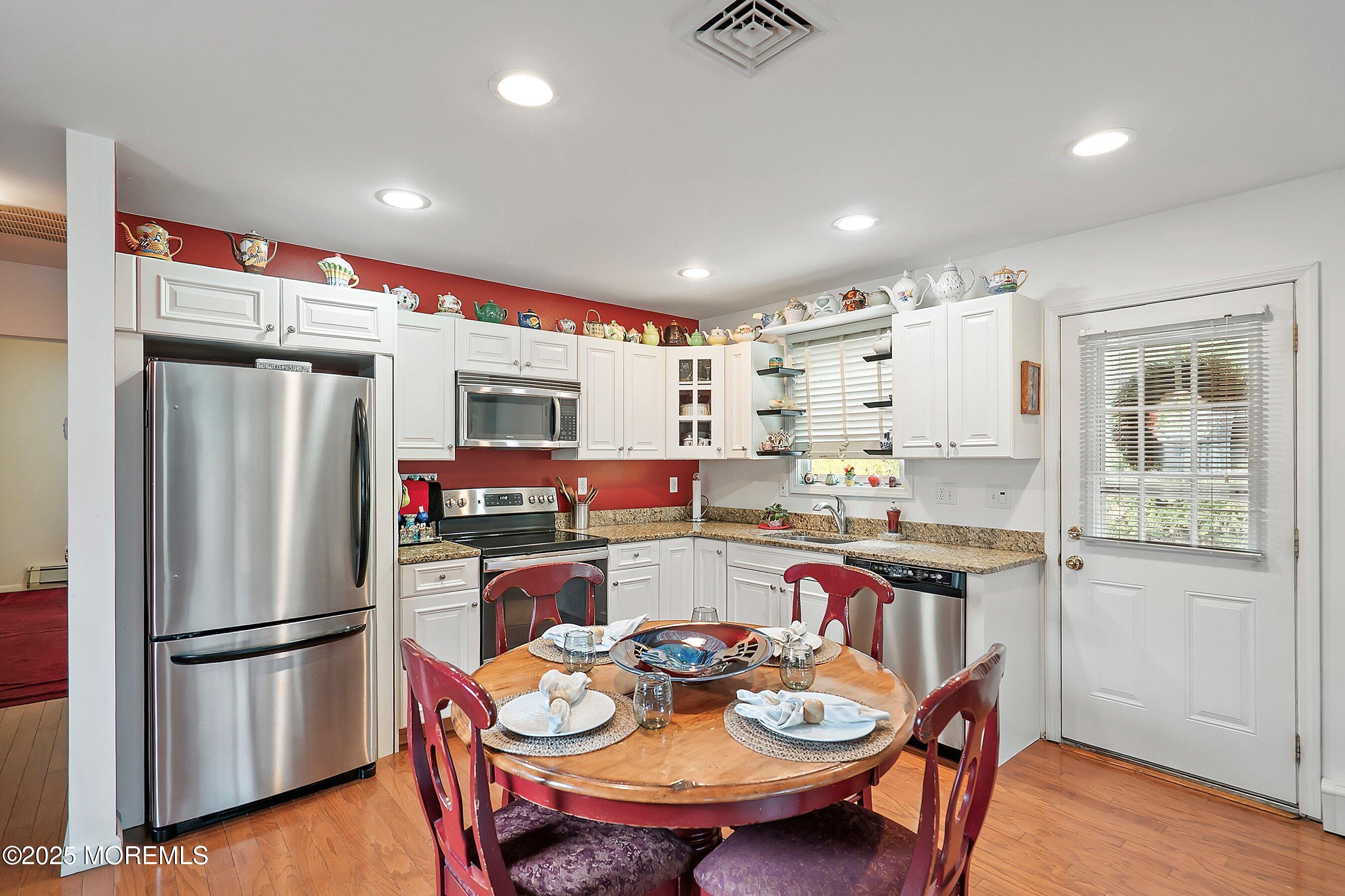 29 Holland Road Middletown, NJ 07748 - Photo 32 of 59 a kitchen with stainless steel appliances a refrigerator a stove a dining table and chairs