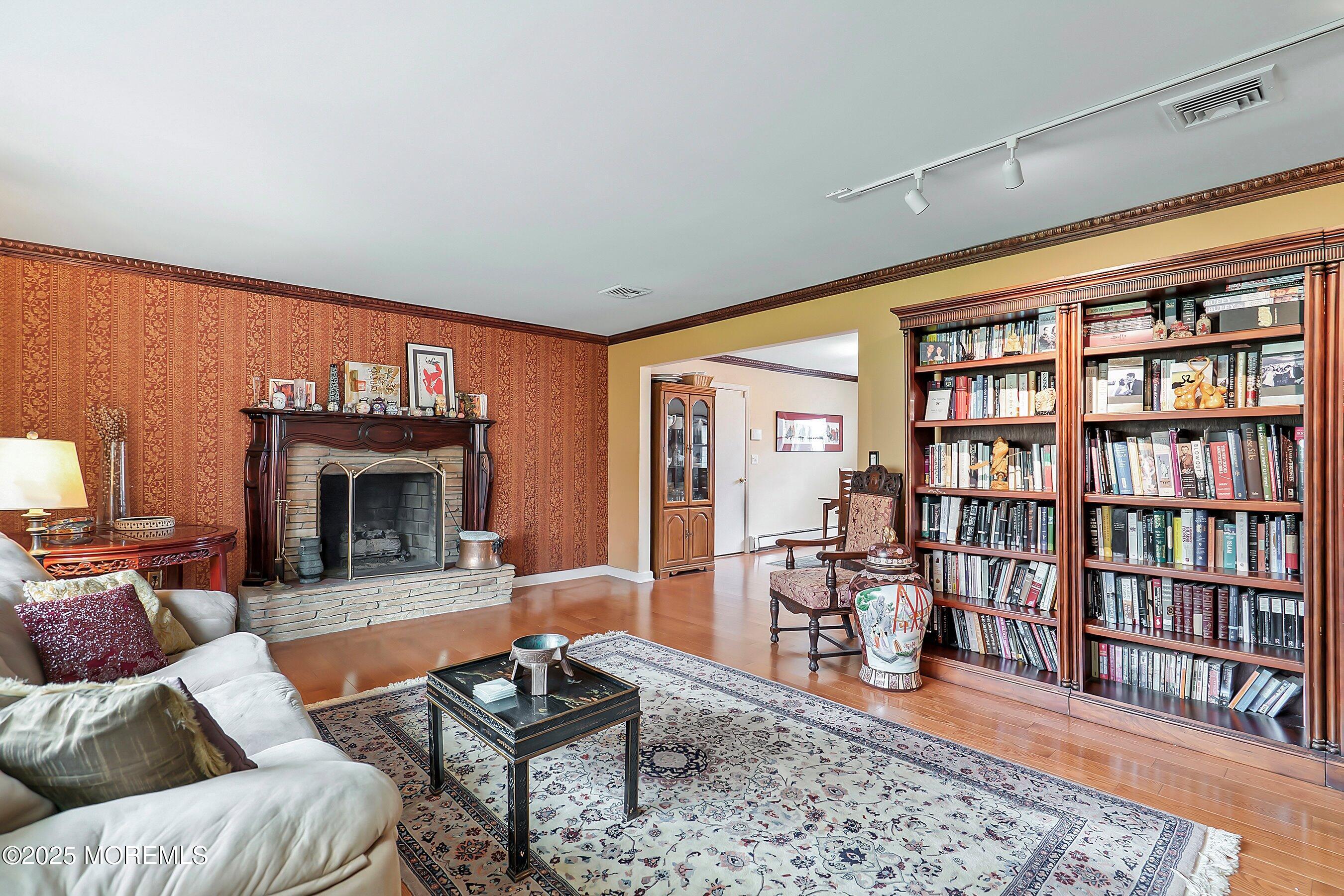 29 Holland Road Middletown, NJ 07748 - Photo 7 of 59 a living room with furniture a bookshelf and a fireplace