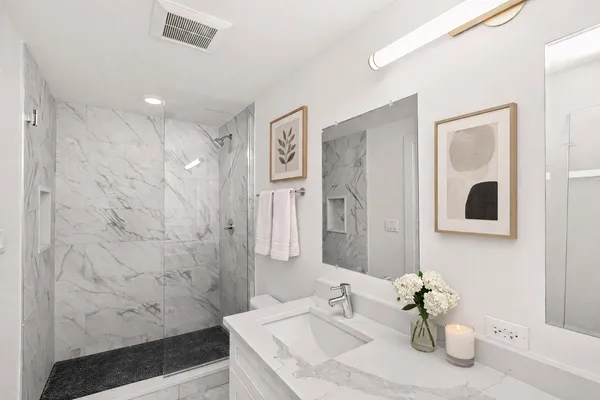 a bathroom with a sink a toilet and shower