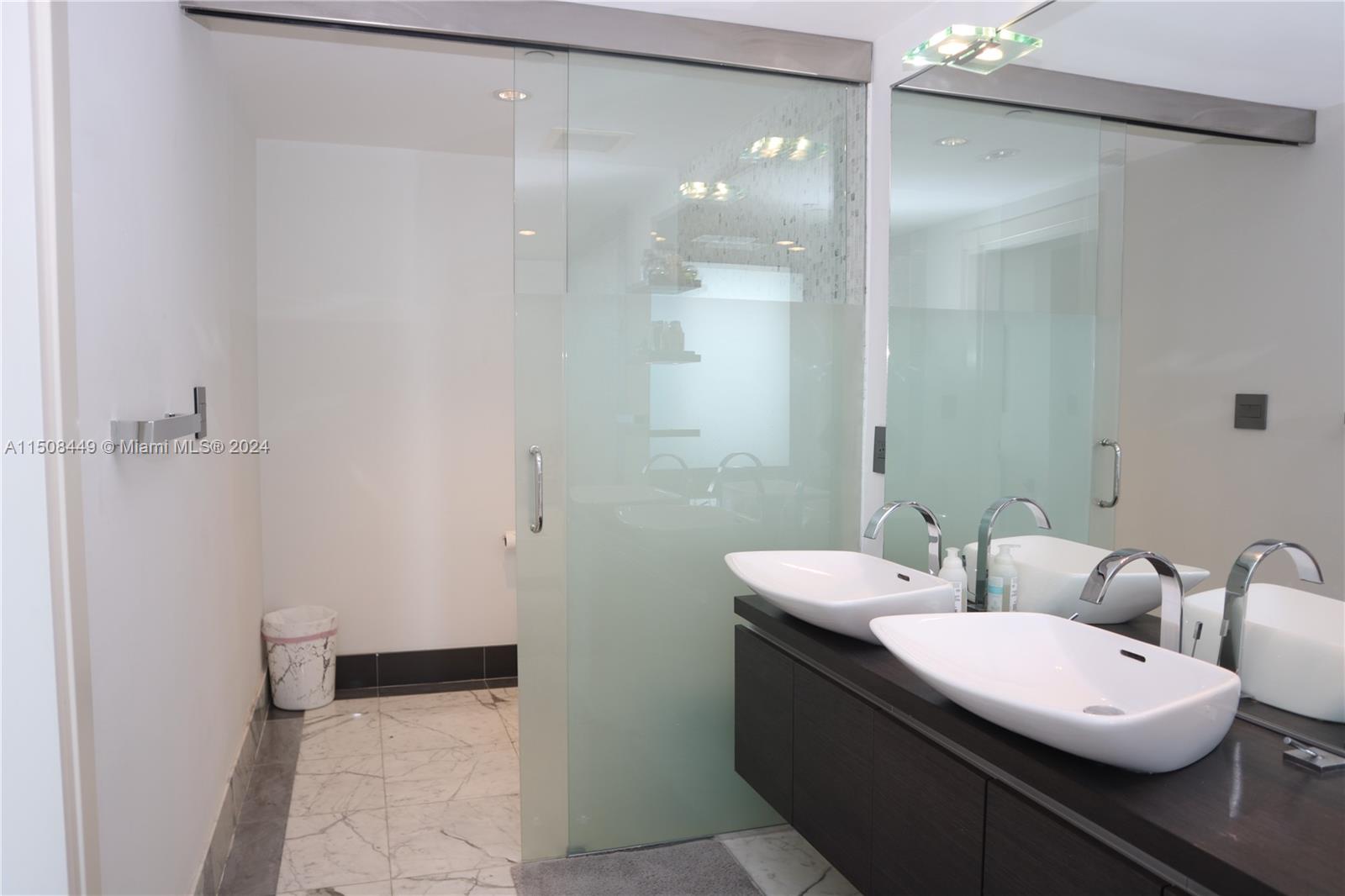 200 Biscayne Blvd Way, Unit 3205 Miami, FL 33131 - Photo 11 of 19 a bathroom with a double vanity sink and mirror