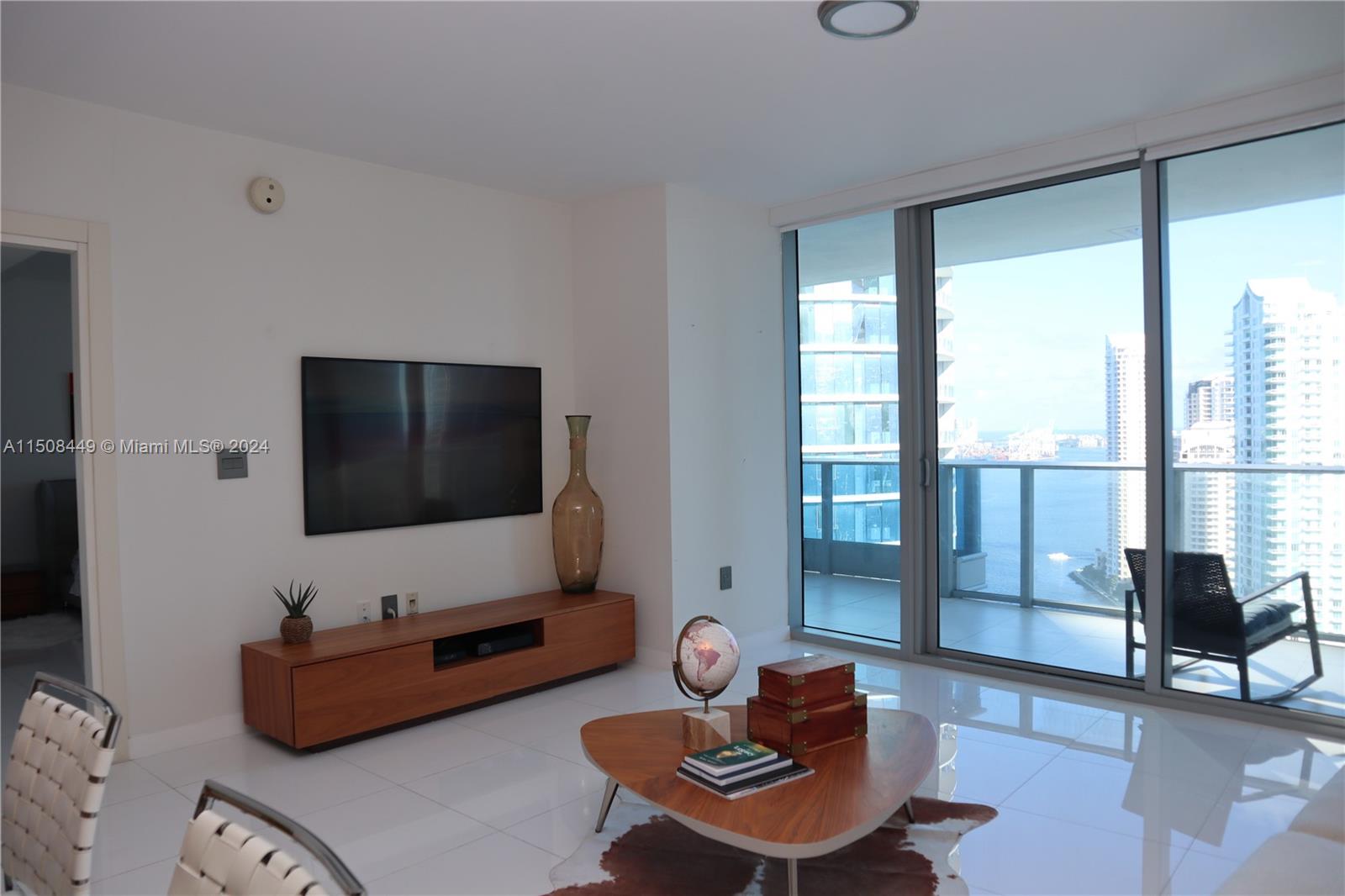 200 Biscayne Blvd Way, Unit 3205 Miami, FL 33131 - Photo 6 of 19 a living room with furniture and a flat screen tv