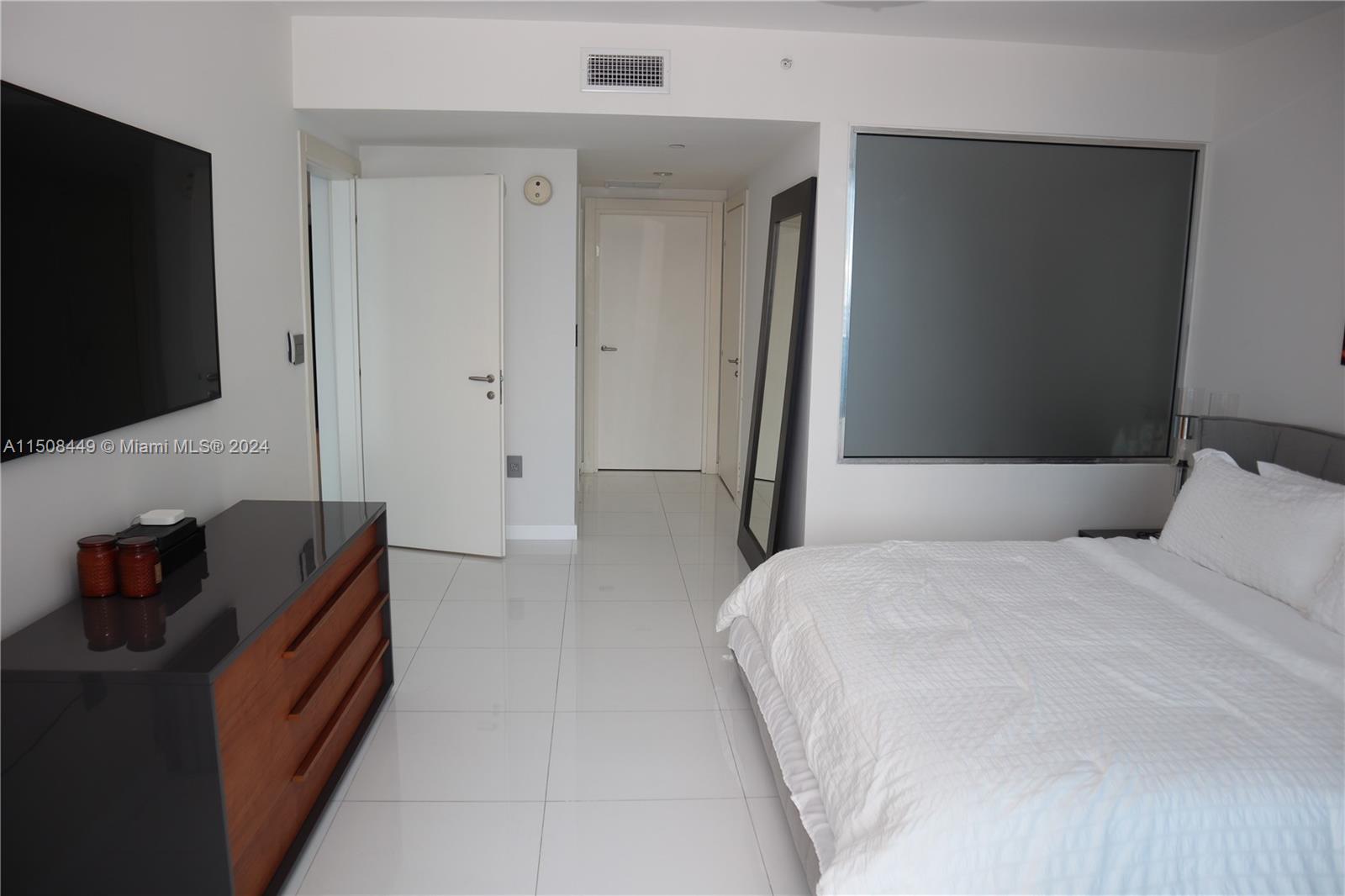 200 Biscayne Blvd Way, Unit 3205 Miami, FL 33131 - Photo 8 of 19 a bedroom with bed and flat screen tv