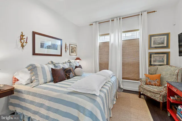 a bedroom with bed couch and window