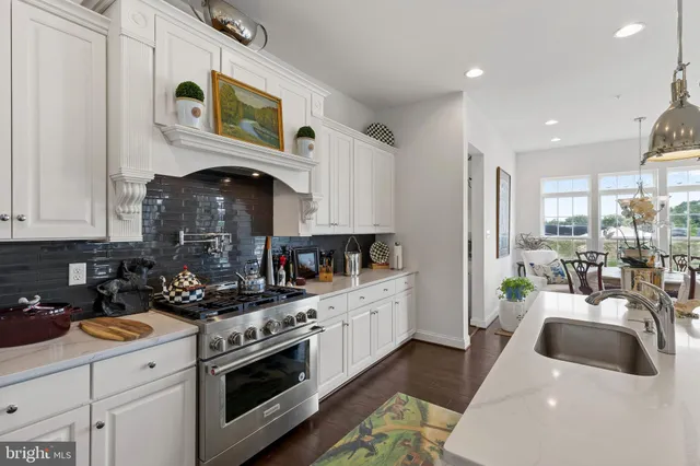 a kitchen with stainless steel appliances a stove a sink a refrigerator and cabinets