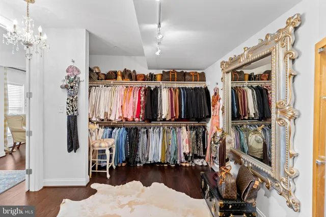 a view of walk in closet with clothes and shoes