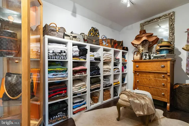 a view of walk in closet with clothes and shoes