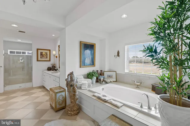 a spacious bathroom with a granite countertop tub a mirror and shower