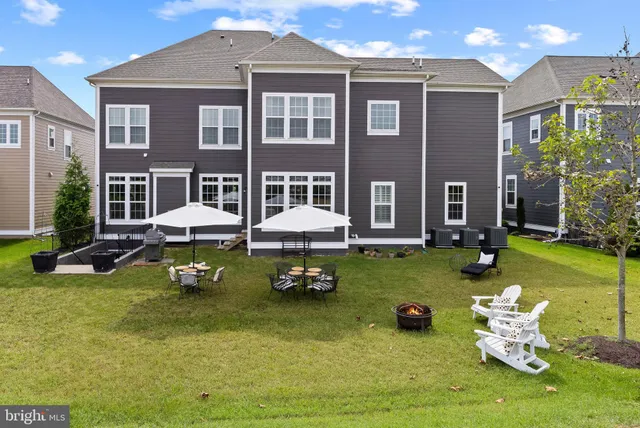 a view of swimming pool with lawn chairs and large trees