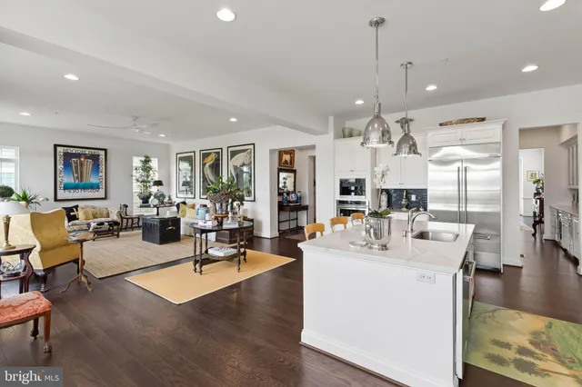 a living room with furniture kitchen view and a wooden floor