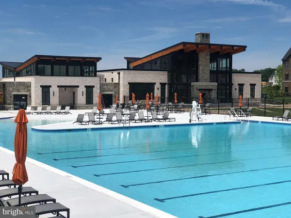 a front view of a house with swimming pool and chair