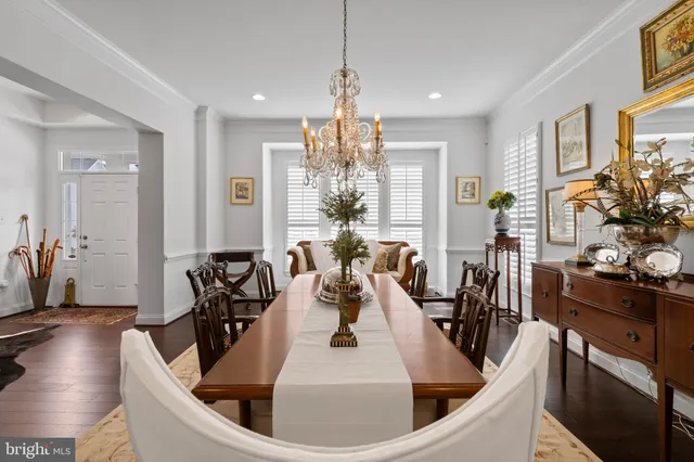 a view of a dining room with furniture a chandelier and wooden floor