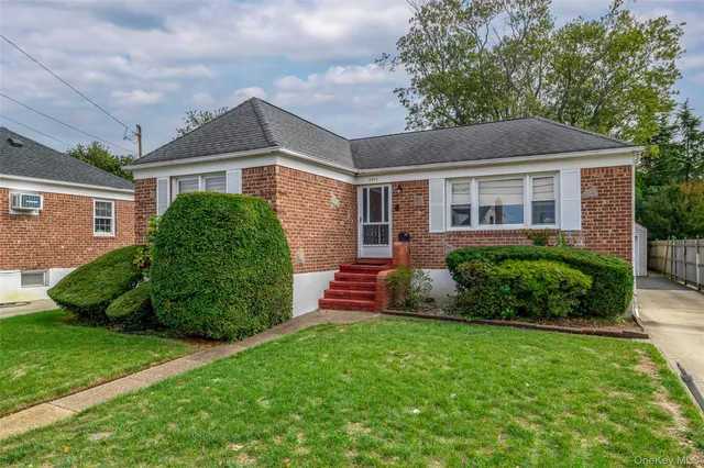 a front view of a house with a garden and plants