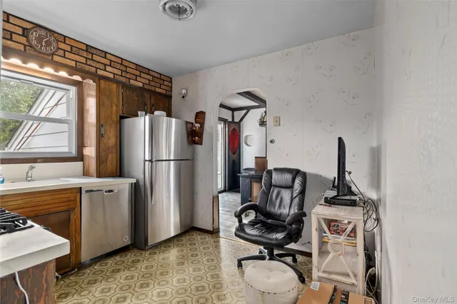 a view of a workspace with furniture and a window